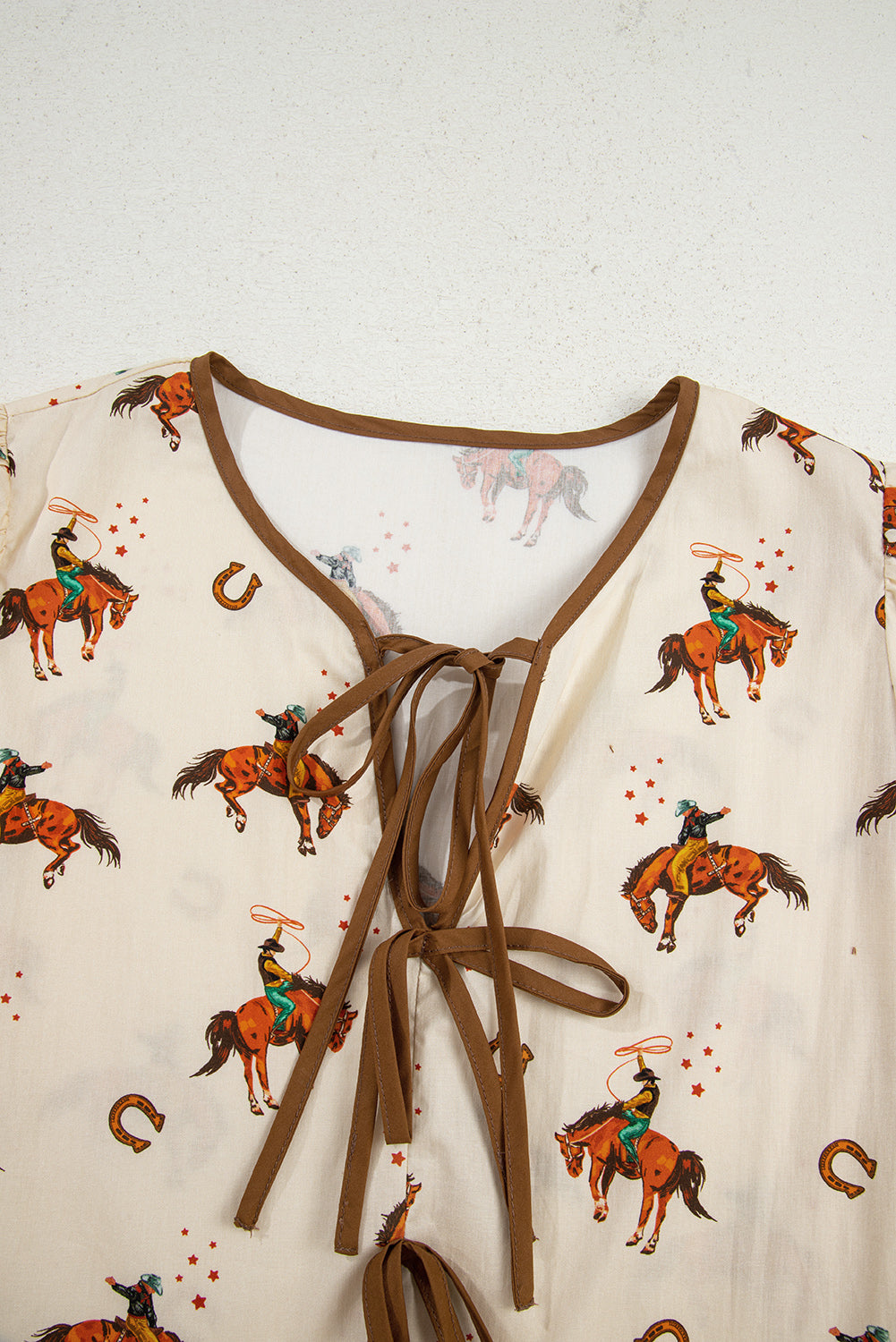 Blouse imprimé cowboy, manches bouffantes, nœud, péplum — abricot